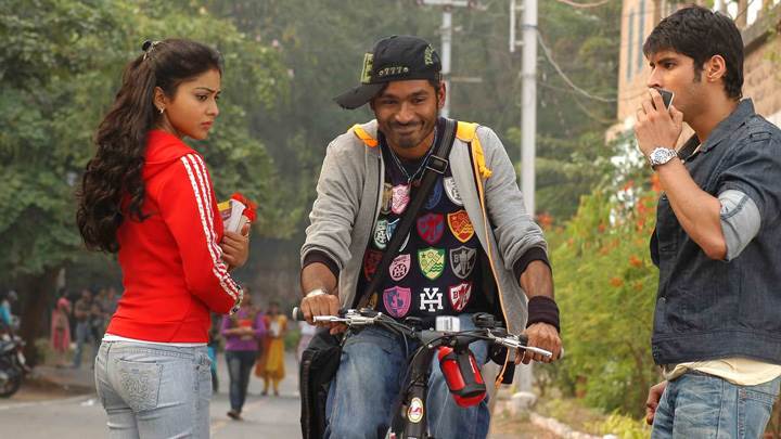 Shriya Saran In Red Top Side Pose N Dhanush On Bicycle In Kutty Movie